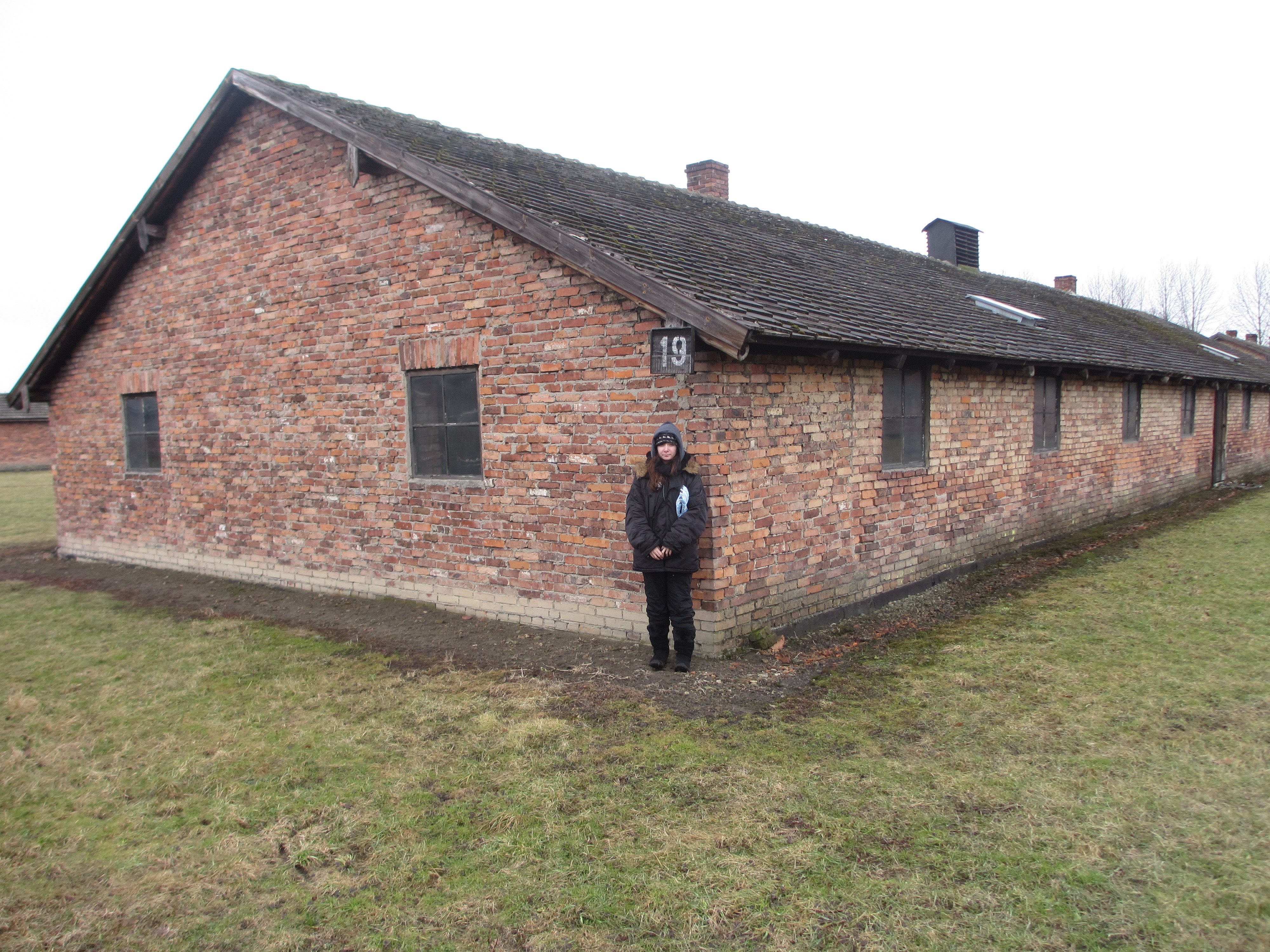 Elise Kolender, Jeffrey's daughter and Pincus' granddaughter, in front of another of the Auschwitz barracks - 2013